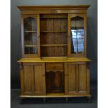 An Arts & Crafts Dresser The Moulded Cornice above two glazed doors and open shelves, the lower