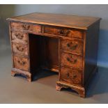 A Mahogany Kneehole Desk, the tooled leather inset top above nine drawers with central kneehole