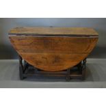 An 18th Century Oak Oval Gate Legged Dining Table, with turned legs and stretchers, 134cm by 117cm