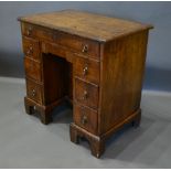 An 18th Century Walnut Kneehole Desk, the moulded cross banded top above eight drawers with brass