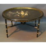 An Oval Lacquered Tray Converted To A Coffee Table, with ring turned tapering legs and crossover