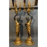 A Pair Of Blackamoor Candelabrum Each With Six Sconces above a figural support and shaped bases,