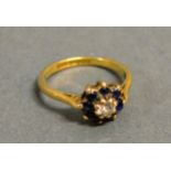An 18ct. Gold Sapphire And Diamond Cluster Ring, with a central diamond surrounded by sapphires,