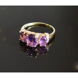 A Yellow Gold Amethyst And Diamond Set Ring with three oval amethyst interspaced with diamonds
