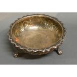 A Victorian Silver Bowl With Embossed Decoration , raised upon three scroll feet, London 1886, by