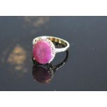 A Yellow Gold Ruby And Diamond Ring Set With A Large Oval Ruby surrounded by diamonds and with