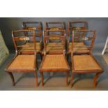 A Set Of Six Regency Style Dining Chairs, with brass inlaid backs above caned seats and with sabre