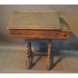 An 18th Century Oak Clerks Desk With A Hinged Top, raised upon turned legs with stretchers