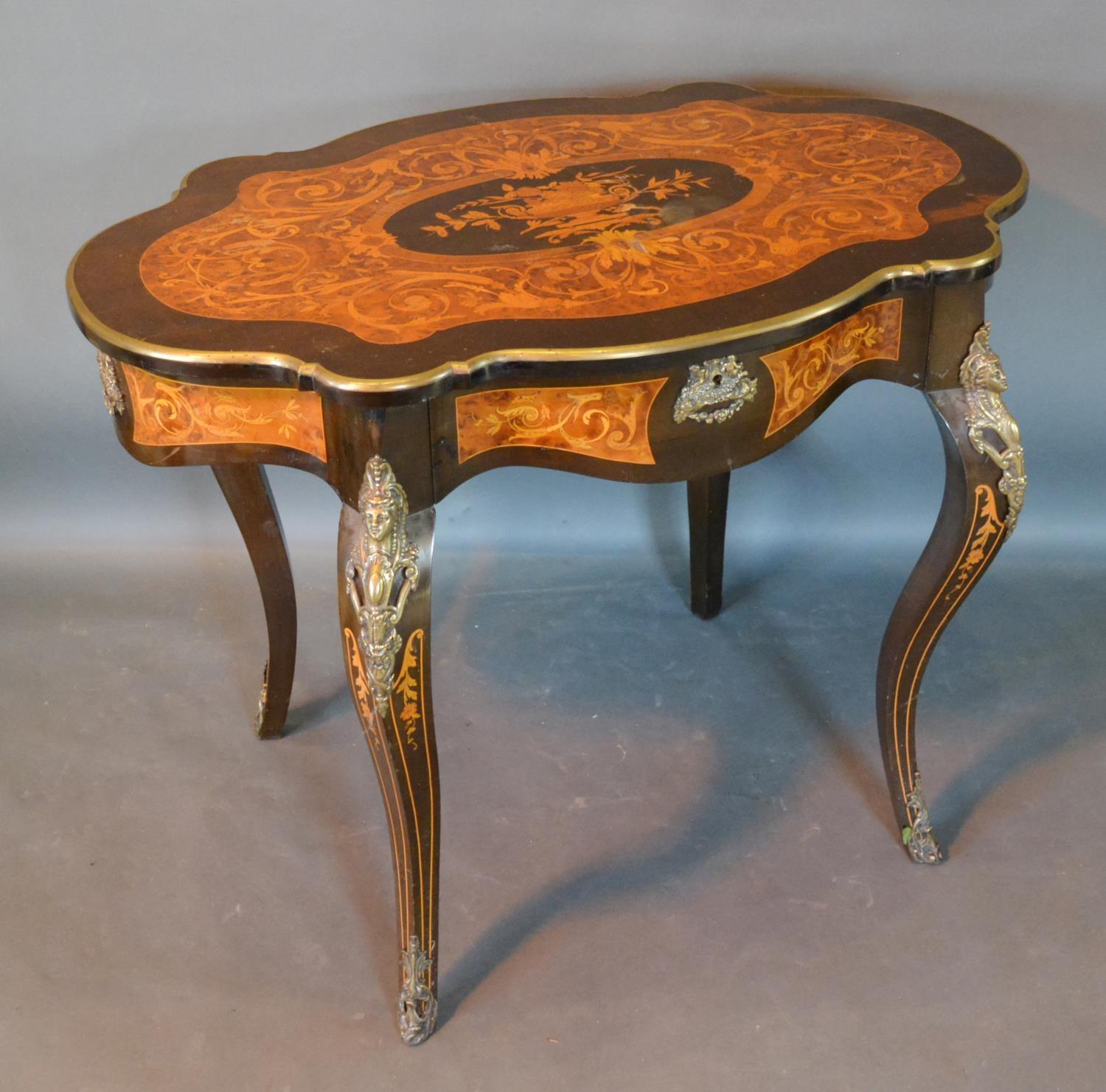 A French Marquetry Inlaid In Gilt Metal Mounted Centre Table, the shaped top above a frieze