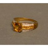 A 9ct Gold Citrine and Diamond Set Ring with a large citrine flanked by bands of diamonds and