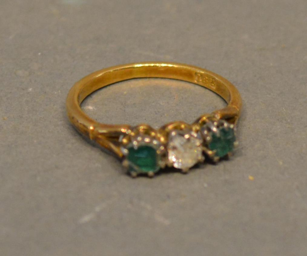 An 18ct. Gold Diamond And Emerald Three Stone Ring, set with a central diamond flanked by emeralds