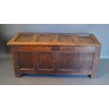 An 18th Century Oak Coffer The Four Panel Hinged Top above a similar front flanked by stiles,