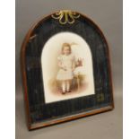 A Late Victorian Over Painted Photograph on Opaque Glass Panel within brass mounted arched glazed