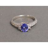 A 9 ct. White Gold, Tanzanite and Diamond Ring with central blue tanzanite stone flanked by diamonds
