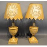 A Pair Of Toleware Table Lamps Each Hand Painted With Reserves, Bows And Swags upon a beige