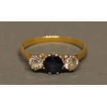 An 18ct. Gold, Sapphire And Diamond Three Stone Ring, with a central sapphire flanked by diamonds