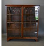 A 19th Century Mahogany Bookcase The Moulded Cornice above two arched glazed doors enclosing