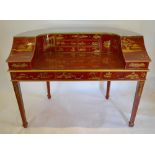 A Red Lacquered And Gilt Chinoiserie Decorated Carlton House Style Desk, with an arrangement of