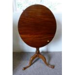 A 19th Century Mahogany Tilt Top Table, The Oval Top above a turned center column, raised upon