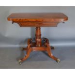 A Regency Mahogany Card Table, The Hinged Top Above A Scroll And Reeded Frieze, raised upon a turned