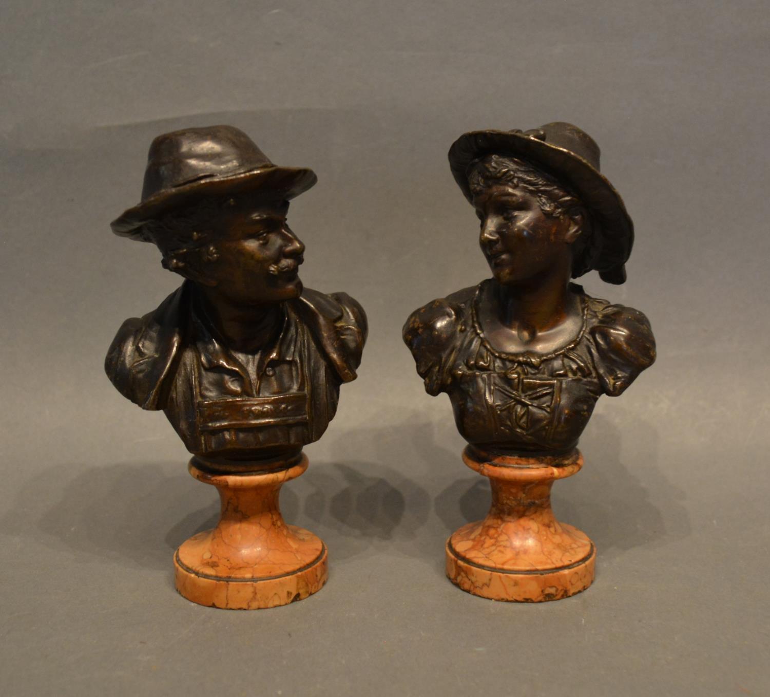 A Pair of Patinated Bronze Busts, depicting a lady and gentleman, raised upon shaped marble plinths,