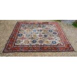 A North West Persian Woollen Carpet with an all over foliate design upon a cream blue and terracotta