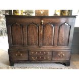 A George III Oak Mule Chest, the plank top above a four panel front converted to doors with brass