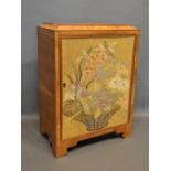 An Art Deco Walnut Small Table Cabinet The Door Embroidered with a vase of flowers, 30cm wide,