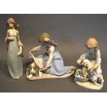 A Lladro Porcelain Group in the form of a Girl With Dog, together with another Girl with Puppies and