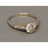 A Platinum Solitaire Diamond Ring, claw set, approximately 0.70 carat, flanked by diamond shoulders