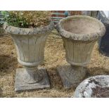 A Pair of Weathered Concrete Garden Urns on square plinth bases, 66cm tall