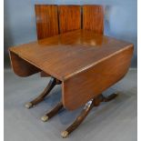 A Mahogany Extending Dining Table with triple splay reeded supports with brass paw caps and with