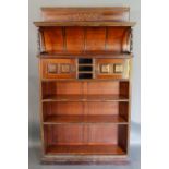 An Arts and Crafts Aesthetic Bookcase, the inlaid top above a shaped alcove with turned uprights,
