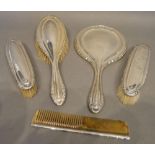 A Birmingham Silver Backed Five Piece Dressing Table Set comprising hand mirror, three brushes and a