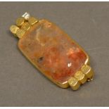 An 18 Carat Gold Stone Set Brooch/Pendant by Geoffrey Turk set with a single diamond