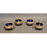 A Set of Four Victorian Silver Mustards with embossed decoration upon hoof supports with blue
