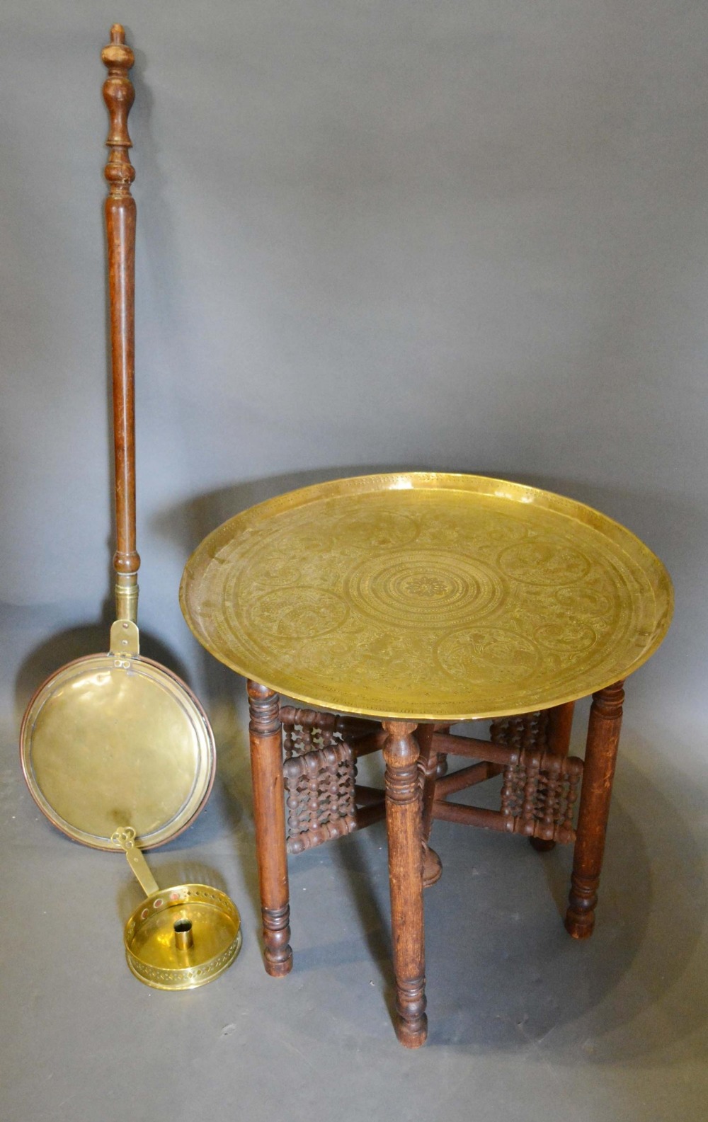 A Benares Brass Tray on Folding Wooden Stand, together with a brass chamber stick and a brass