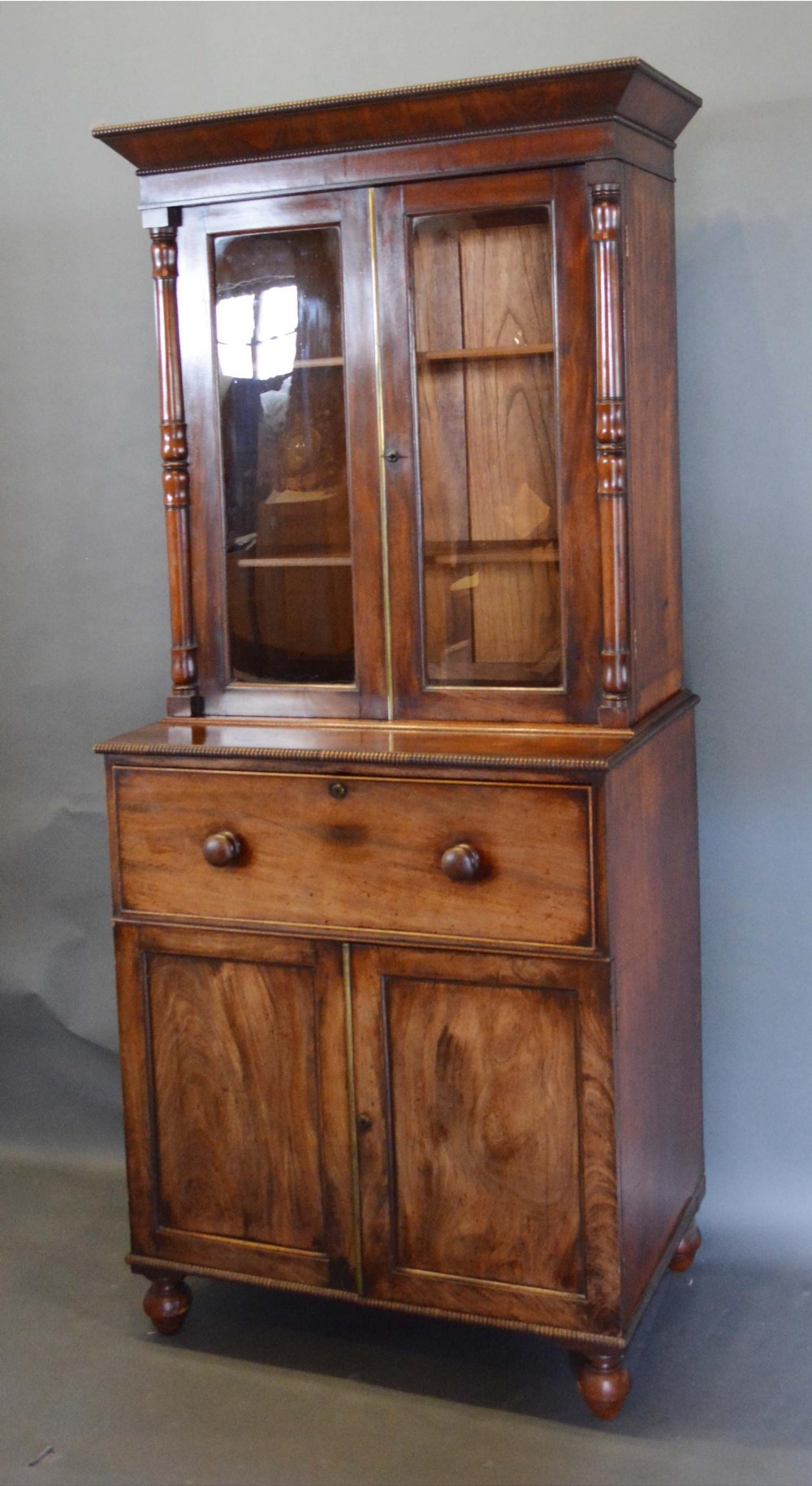 A William IV Mahogany Secretaire Bookcase, the moulded cornice above two glazed doors enclosing