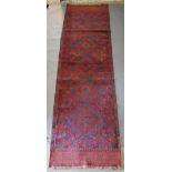 A North West Persian Woollen Runner with an allover design upon a red and blue ground within
