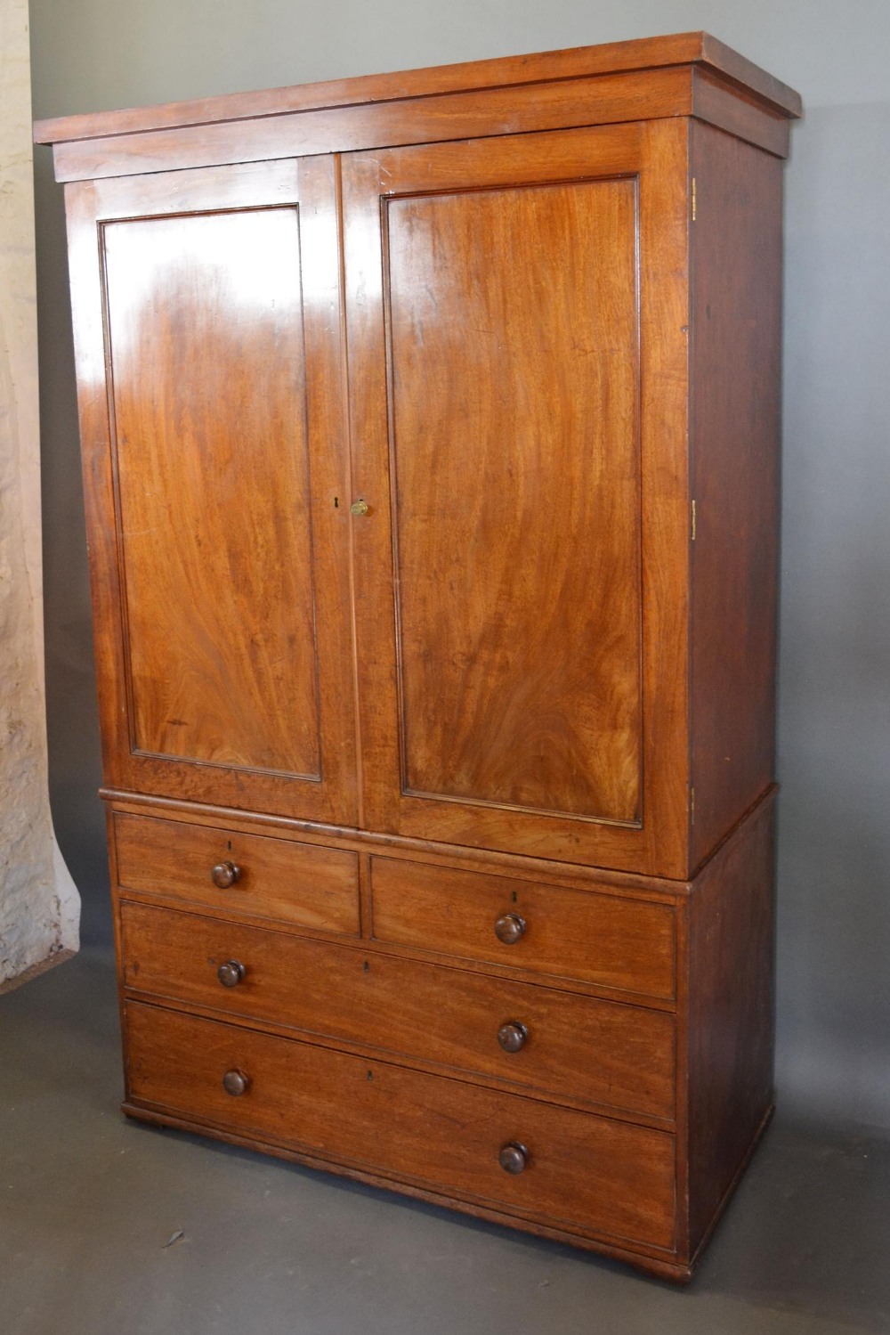 A 19th Century Mahogany Linen Press, the moulded cornice above two panelled doors enclosing