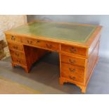 A Yew Wood Twin Pedestal Desk, the tooled leather inset top above nine drawers with brass handles
