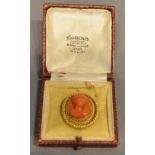 An 18 Carat Gold Oval Brooch with relief carved coral centre depicting a classical female bust