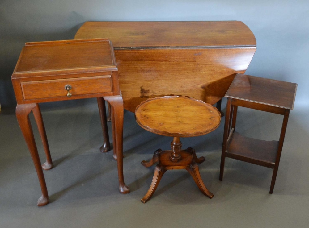 A George III Mahogany Oval Drop Flap Dining table with turned legs and pad feet, together with three