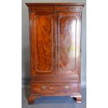 An Early 19th Century Mahogany Hall Cupboard, the moulded cornice above two doors enclosing a