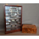 A Chinese Hardwood Collectors Cabinet with a glazed door enclosing an arrangement of shelves with