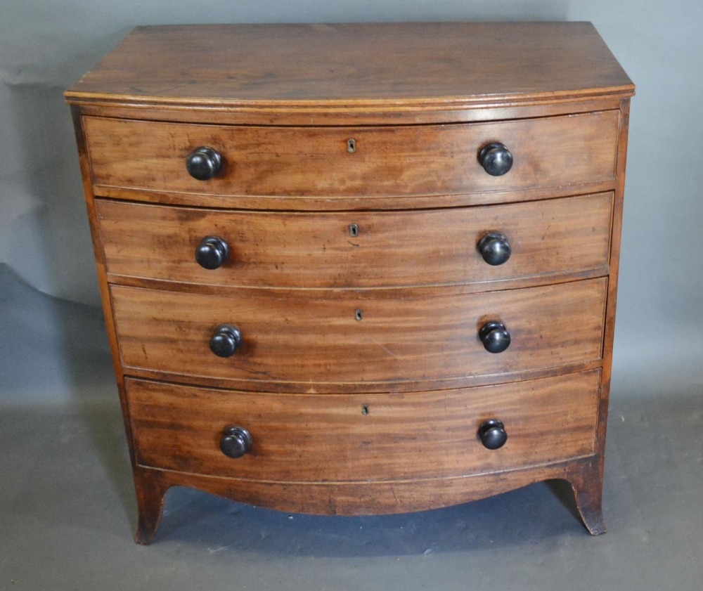 A 19th Century Mahogany Bow-Fronted Chest of four long drawers with knob handles raised upon
