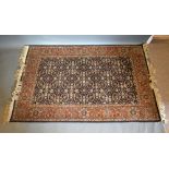 A North West Persian Woollen Rug with an all over design upon a dark blue, cream and red ground