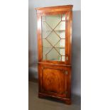 A Mahogany Standing Corner Cabinet with an astragal glazed door enclosing shelves, the lower section