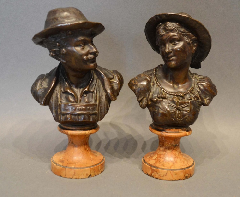 A Pair of Patinated Bronze Busts depicting a lady and gentleman, raised upon shaped marble