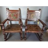 A pair of throne chairs, each with a polychrome leather back and seat raised upon shaped supports